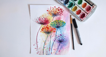 Watercolour image of flowers with paint tray and brush to the side