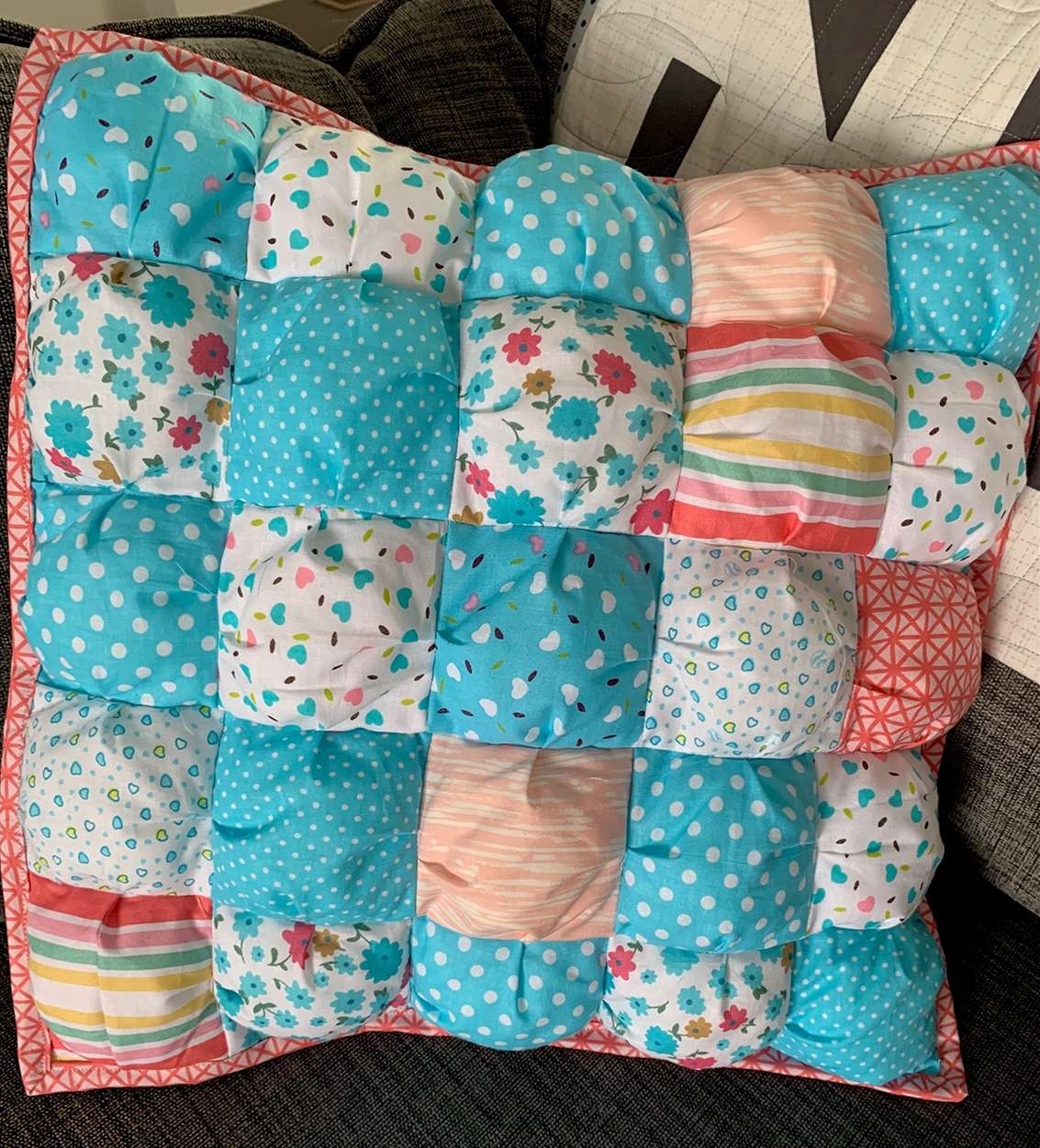Quilted puff pillow sitting on a couch