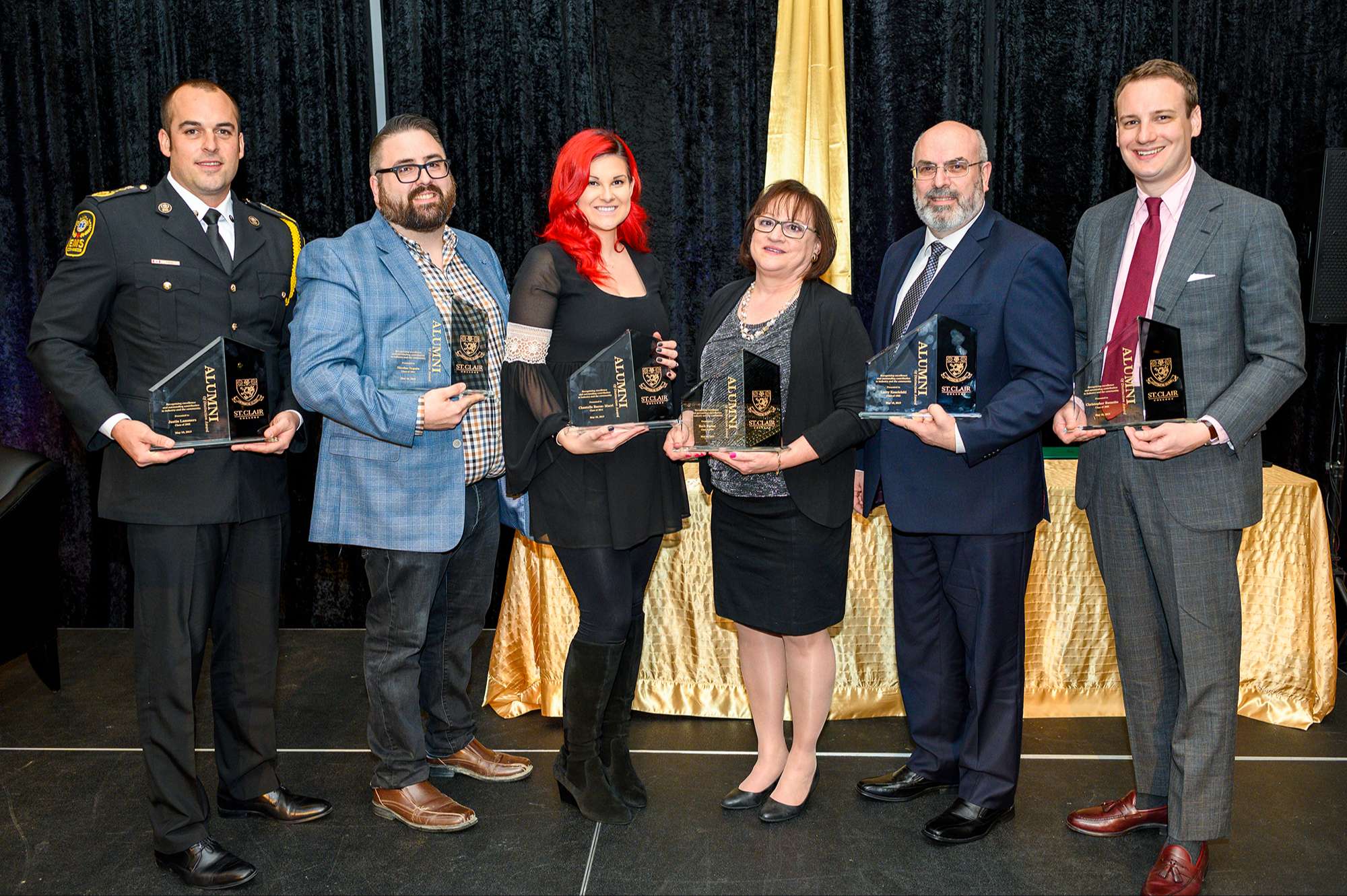 The 2019 alumni of distinction recipients with their trophy's.
