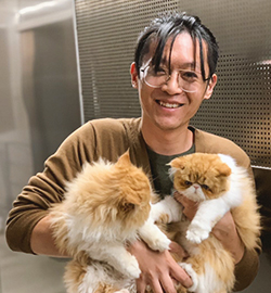Tianrui Zhu holding two cats