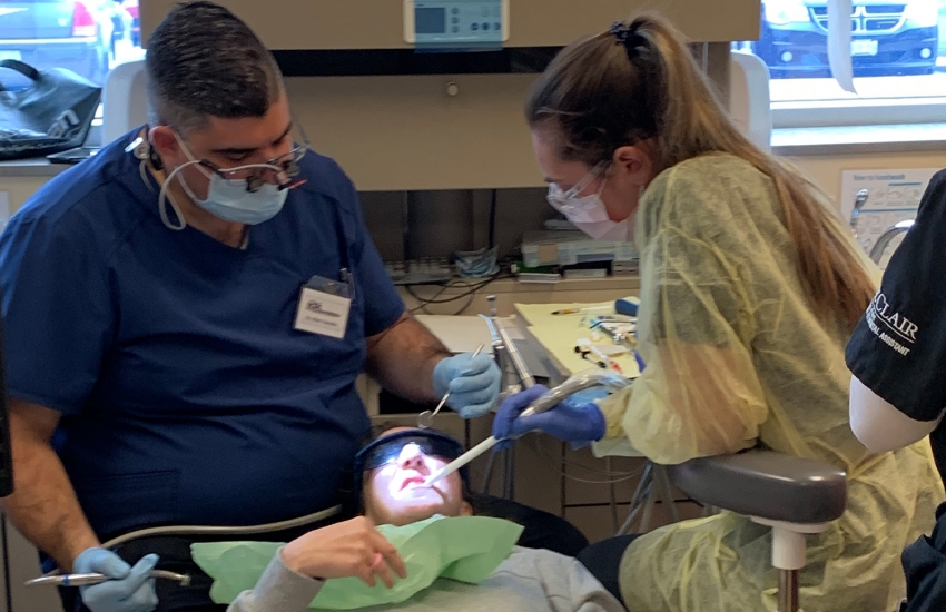 Dentist and hygienist cleaning the teeth of a patient.