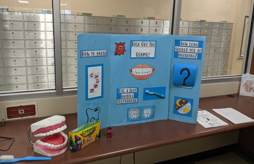Kick Out the Germs poster on desk with mouth prop