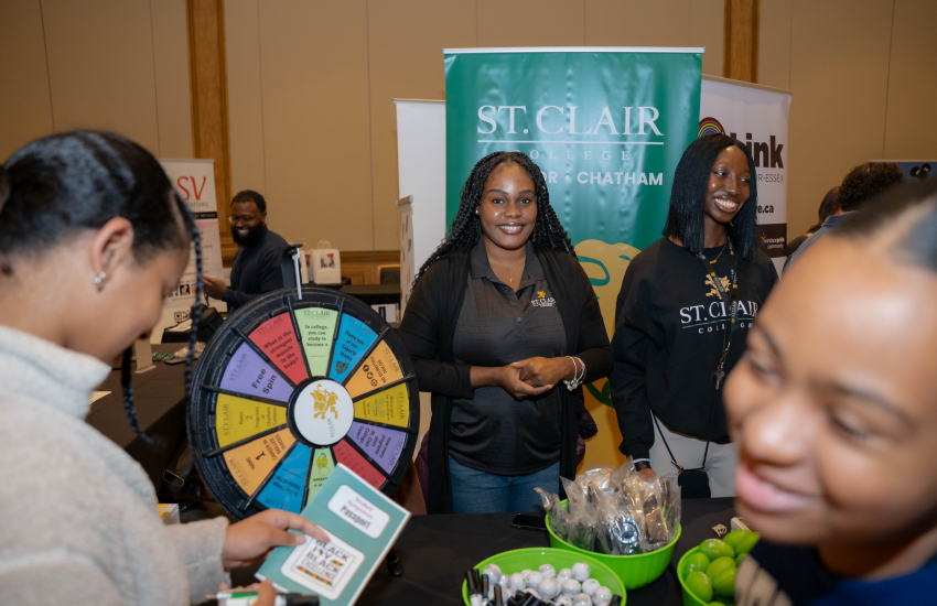 St. Clair representatives and attendees near spin wheel