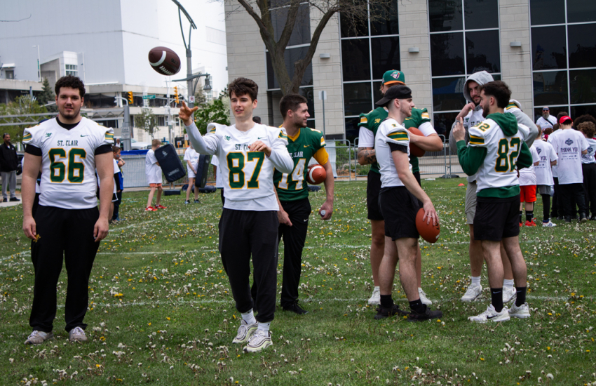 Saints Football player #87 tossing football amongst teammates 