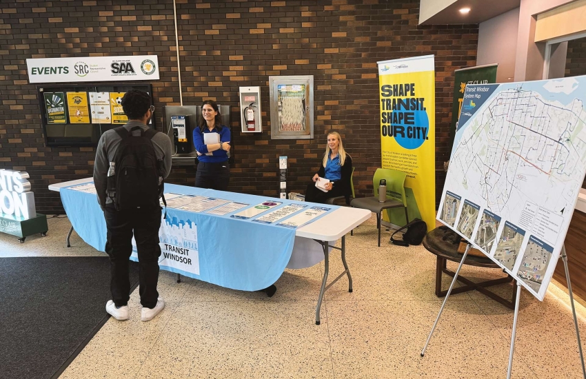 Transit Windsor workers sitting at desk in front entrance of Main Windsor Campus
