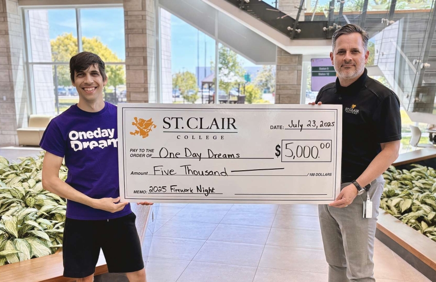 Jason Soulliere of Oneday Dreams stands with St. Clair College President Michael Silvaggi holding a giant cheque