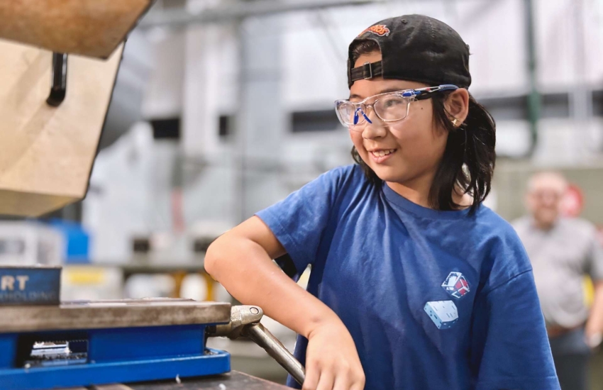 A camper in the Skills Ontario Trades and Tech Camp working on a CNC Machine