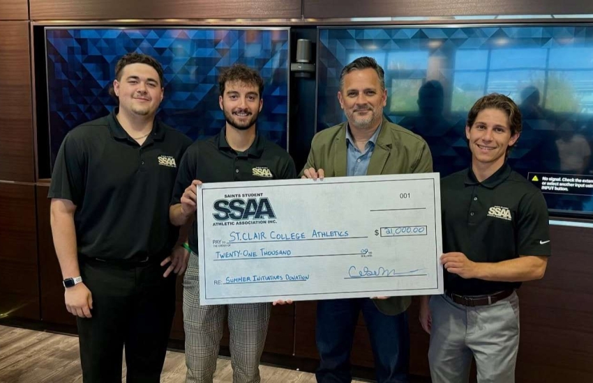 SSAA Board members Andrew Weiler, George Karatzias and Matteo Palumbo stand with St. Clair College President Michael Silvaggi to deliver a cheque for $21,000 to Saints Athletics on Sept. 19, 2025.
