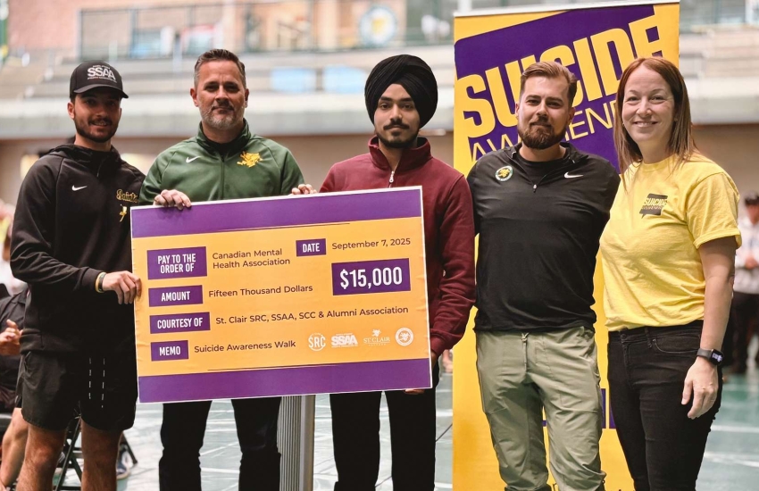 St. Clair College President Michael Silvaggi and student government leaders stand with Nicole Sbrocca of the CHMA to present a cheque