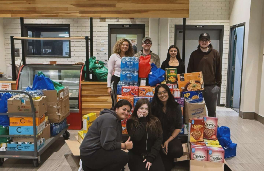 Students in the PSI/PF Society show off some of the food items collected