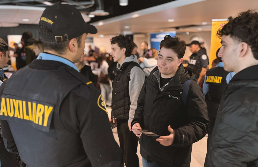 St. Clair College students engage with an auxiliary police officer at the First Responders Career Fair