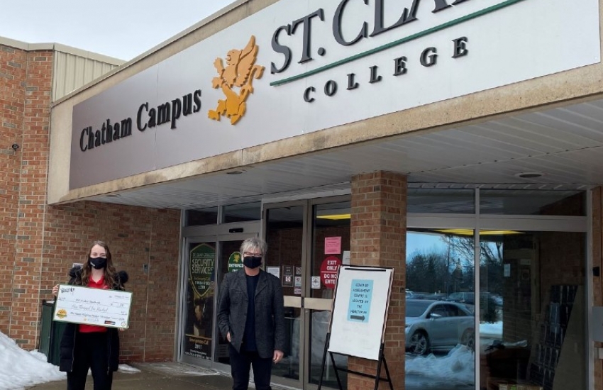 Jeff Burrows presents TSI president Hannah LaCroix with a cheque for the student food bank.