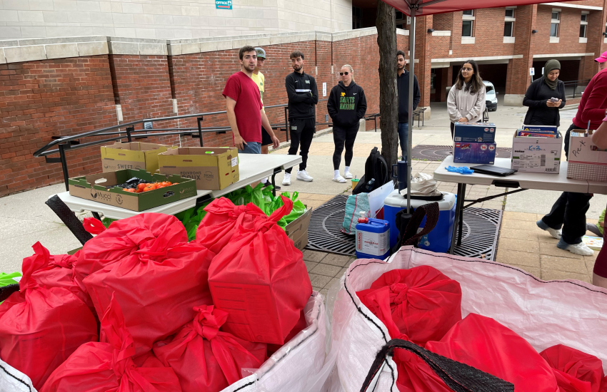 Wide shot of tables with food items and students in background