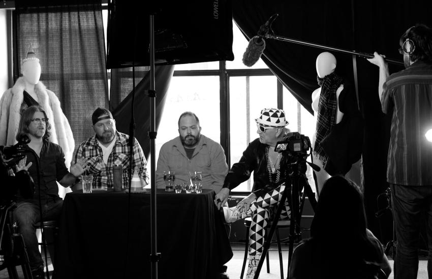 On set photo with actors at a table