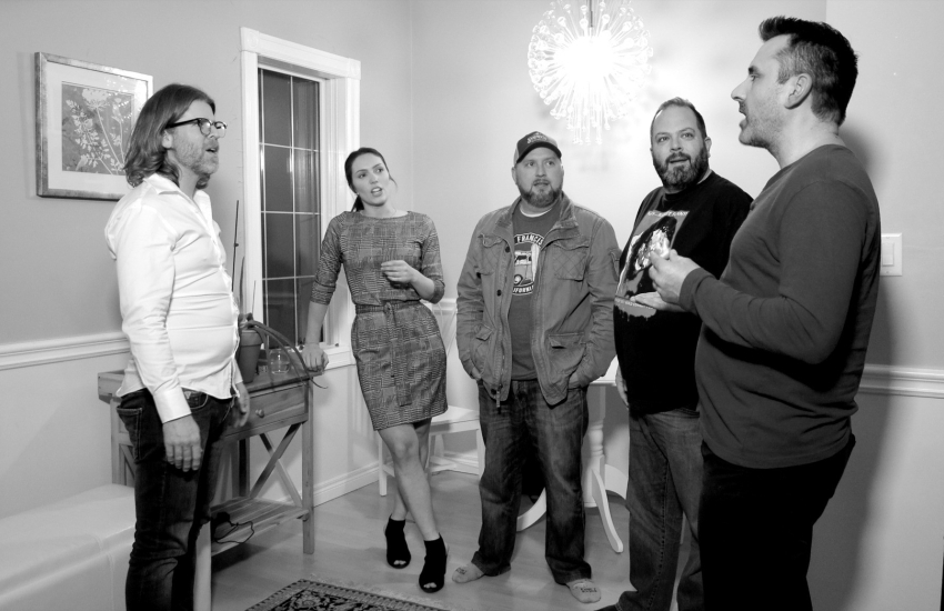 On set photo with actors standing in room