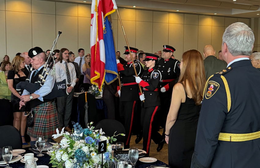 People standing for bag pipe led flag procession 