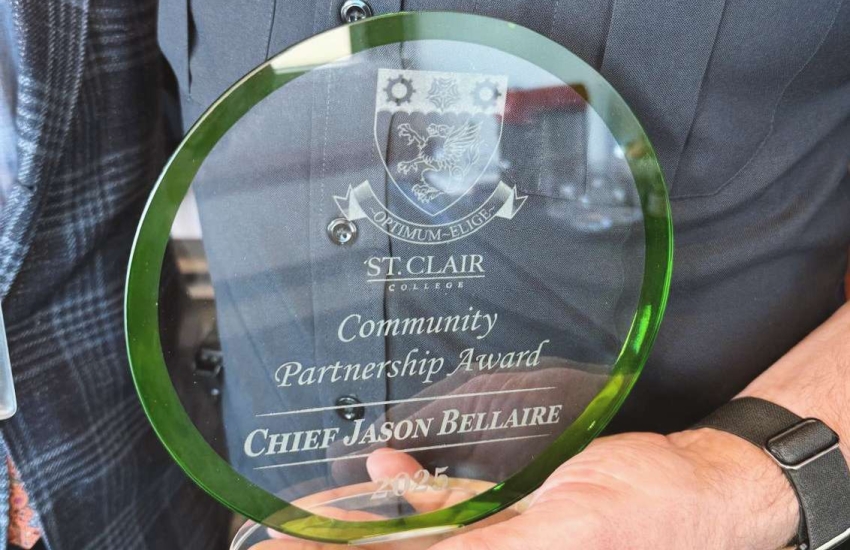 Windsor Police Chief Jason Bellaire holds his St. Clair College Community Partnership Award