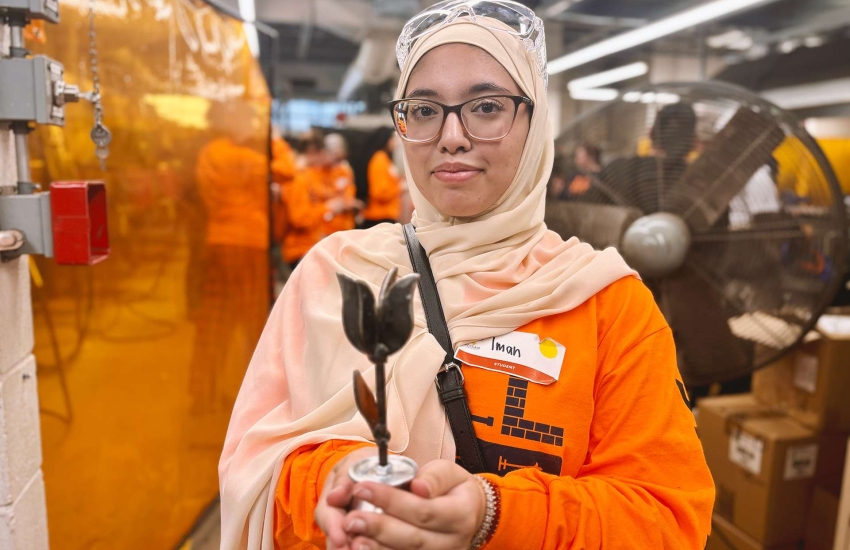 A student holds up a welded tulip she made 
