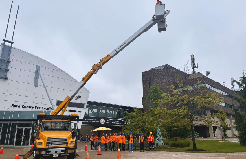 Students get lifted 60 feet up in a bucket to simulate heights reached by powerline workers