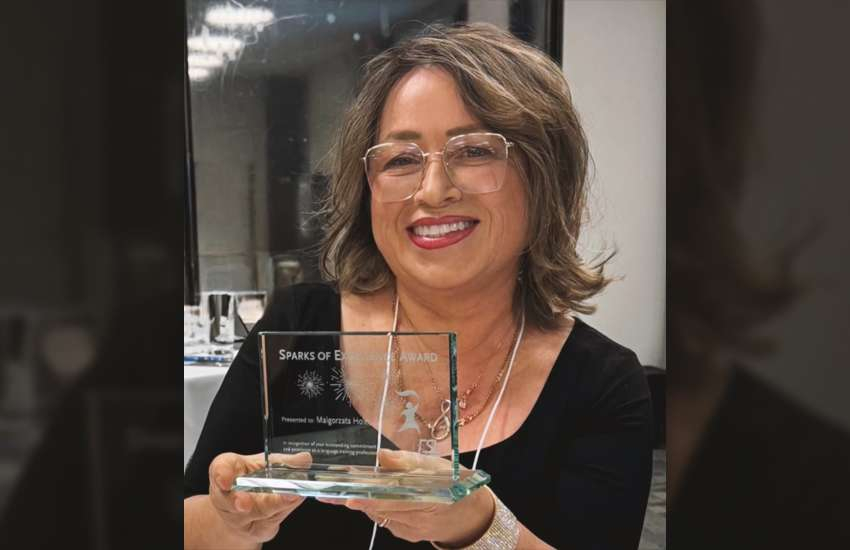 Margaret Holec holds her Sparks of Excellence Award