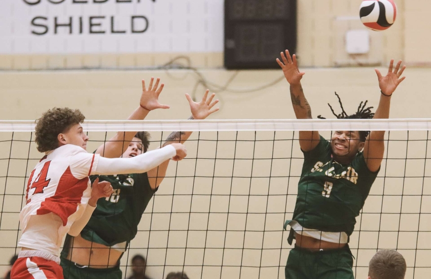 Saints Men's Volleyball player Zach Walls attempts a block