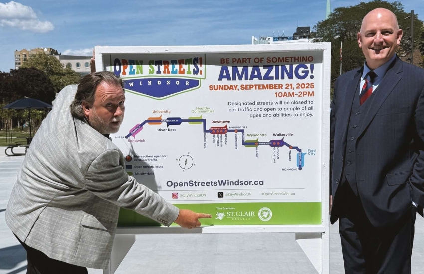 College VP and Windsor Mayor standing with event sign