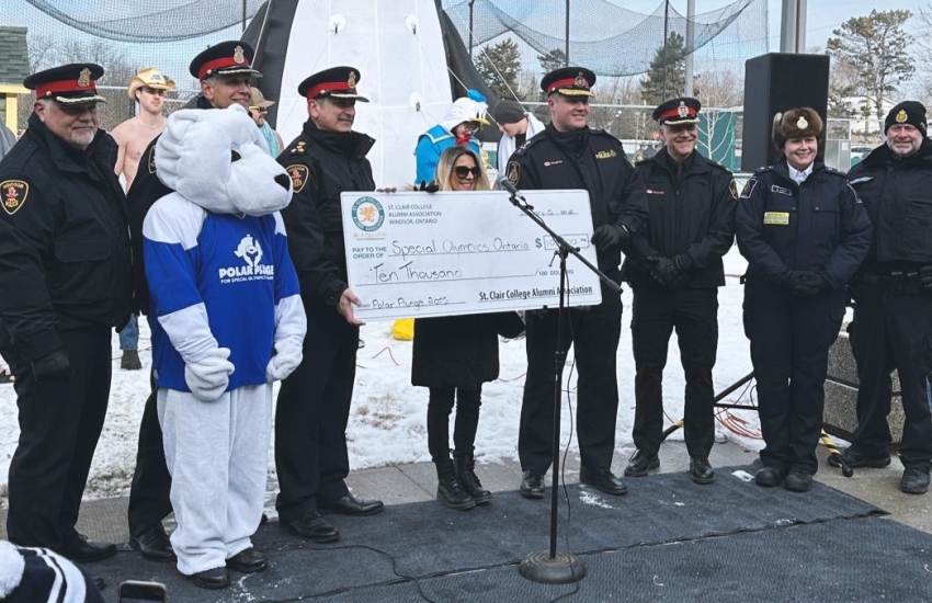 Belinda Bulhoes of the St. Clair College Alumni Association presents a cheque for $10,000 to members of Windsor Police