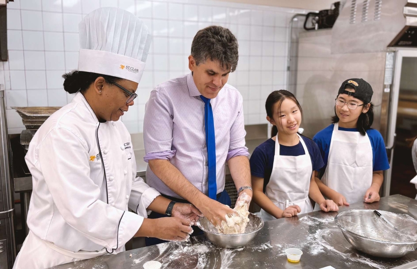 Campers and instructors help Windsor-Tecumseh MPP Andrew Dowie prepare a pizza