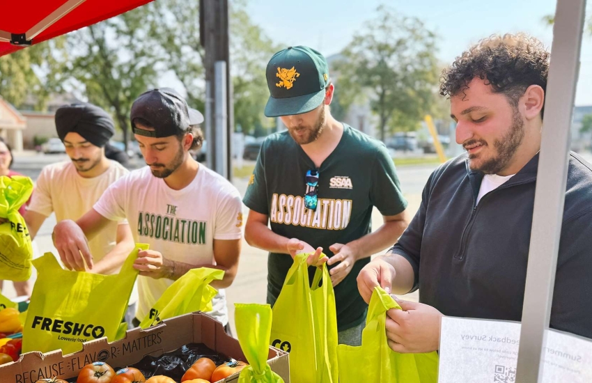 St. Clair College representatives handing out bags of food 