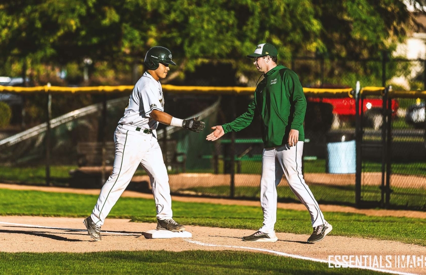 Tristan Bouchat congratulates a player at first base 