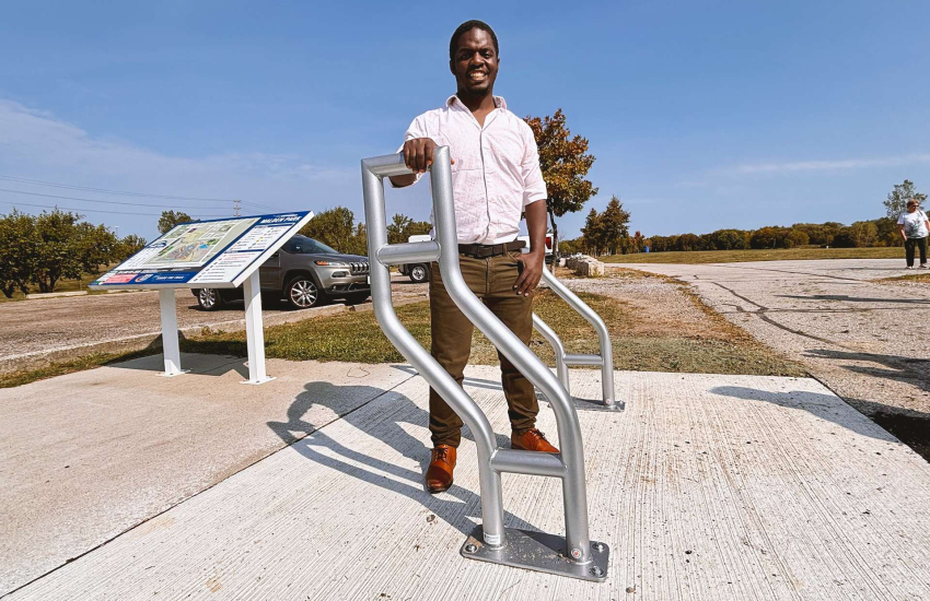 Student posing with self-designed bike racks