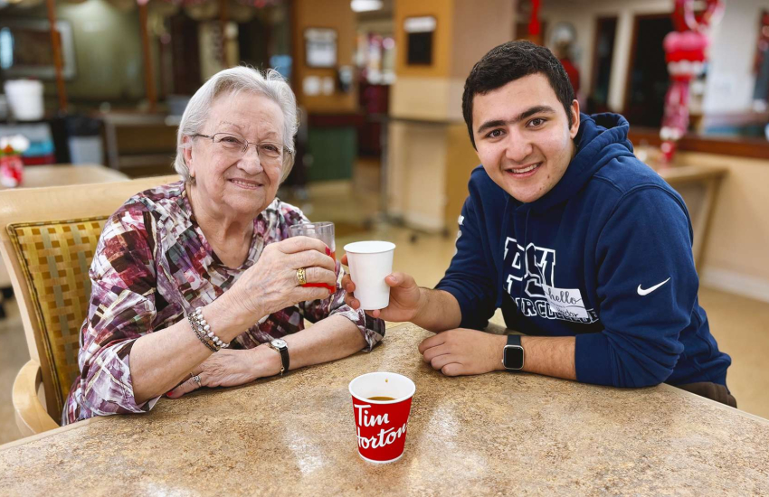 Schlegel Villages neighbour Isabel Ouellette and St. Clair College student Haidar Ghassan enjoy coffee and companionship