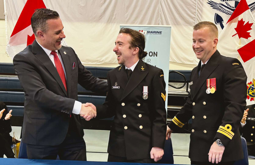 St. Clair College President Michael Silvaggi shakes hands with reservist and St. Clair student Blake Blanchard, while Lt. Commander Chris Elliott of HMCS Hunter looks on