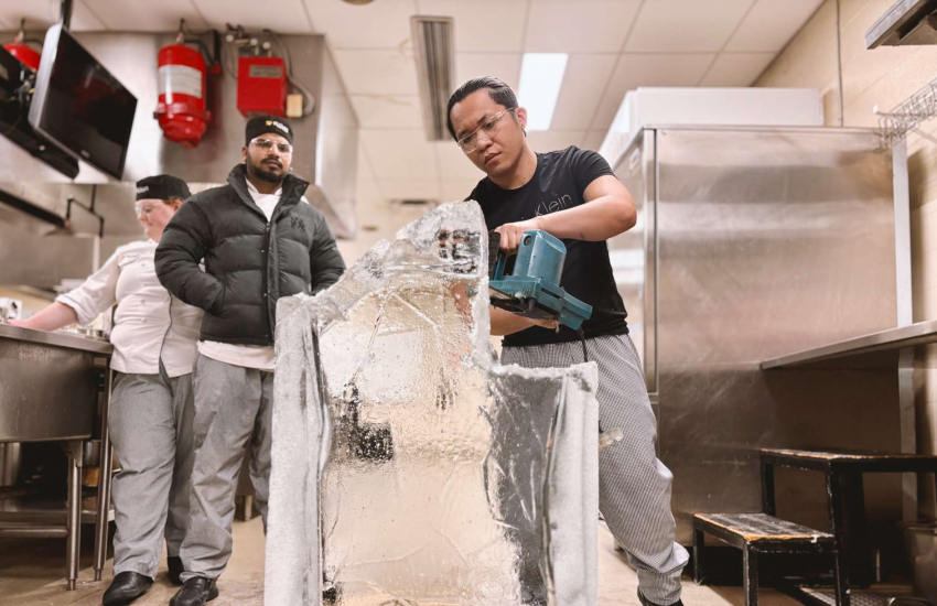 A second-year student in the Culinary Management program takes a chainsaw to a block of ice – transforming it into a work of art at the culinary lab