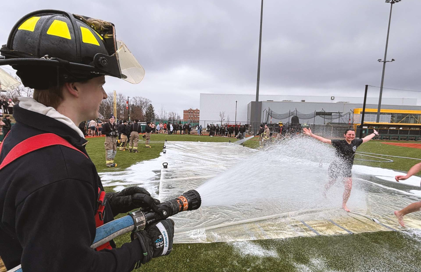 A St. Clair College student gets hosed down by a Pre-Service Firefighter student
