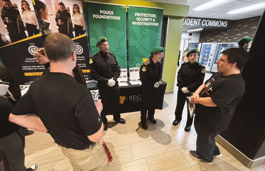 Members of the St. Clair College Honour Guard speak with prospective PSI and Police Foundations students during the St. Clair College Spring Open House at Main Windsor Campus