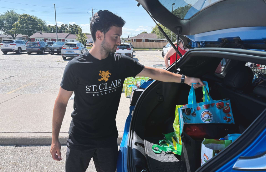 Man putting bag in trunk of car
