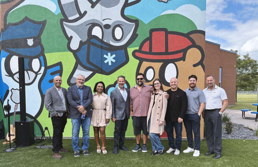 Barry Zekelman is flanked by community supporters in front of the Haunted Zoo mural at the newly reimaged Zekelman Safety Village