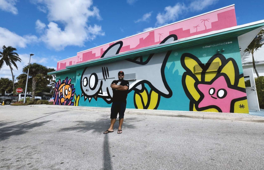 Man outdoors in front of fish themed mural
