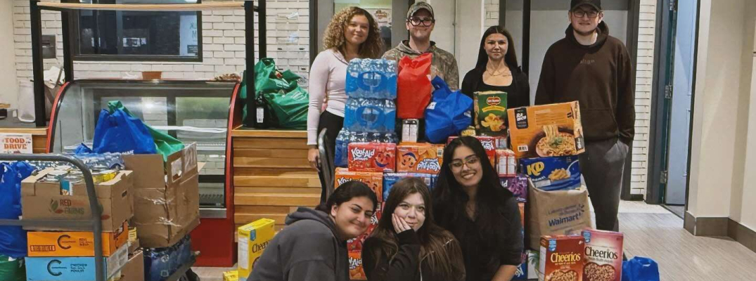 Students in the PSI/PF Society show off some of the food items collected