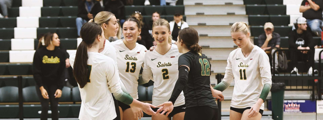 Womens volleyball players celebrating on court