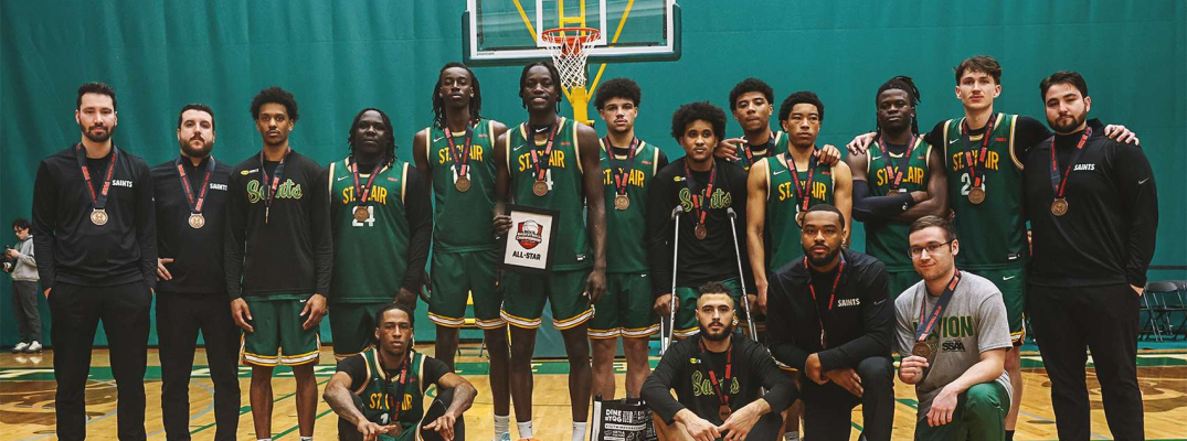 Saints Men's Basketball team poses with bronze medals