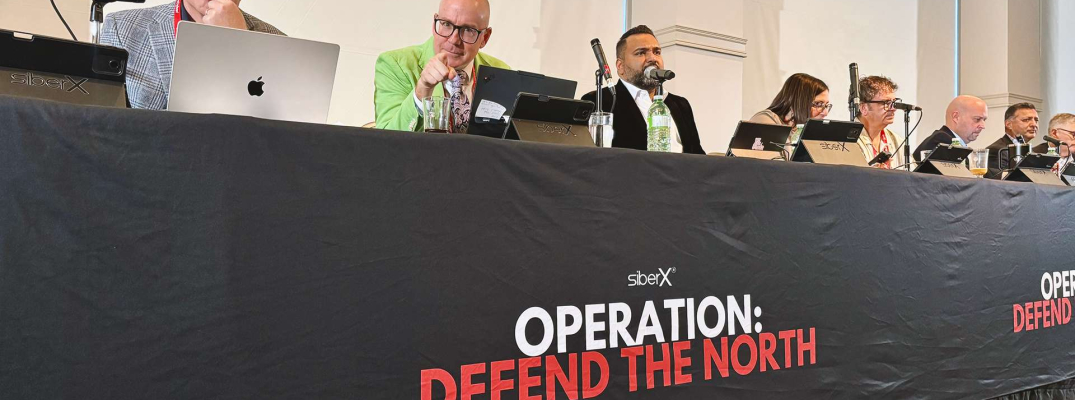 Panel of speakers at table with microphones