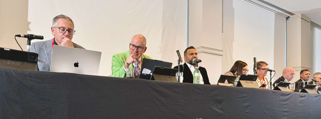 Panel of speakers at table with microphones