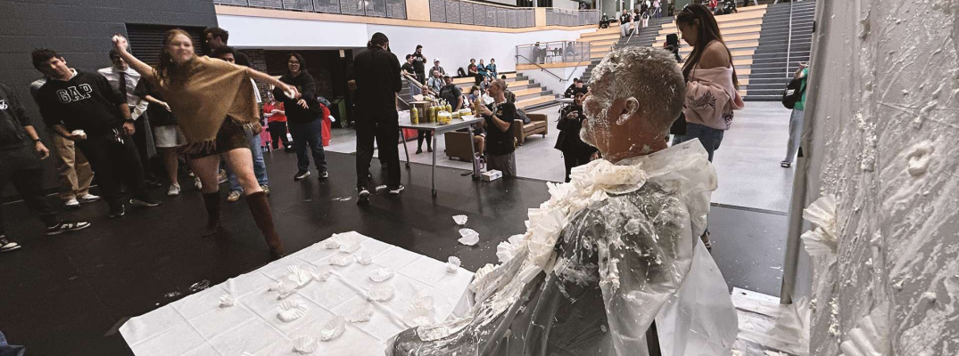 Student McKinley Lenehan throws a pie at Prof. Rick Beauchamp during the United Way Week fundraiser 