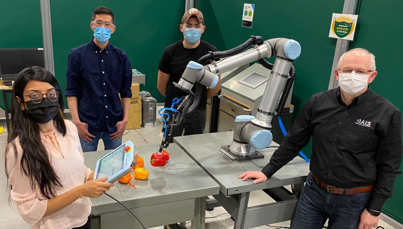 St. Clair students Khushboo Patel, left, Yu Wang and Ulises Martinez are working with adjunct professor Nick Dimitrov, right, to automate sweet pepper packaging for a Leamington greenhouse.