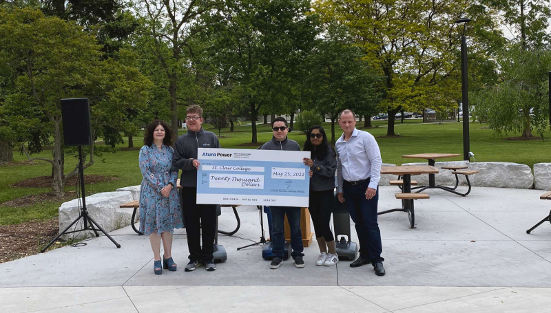 Community Integration through Cooperative Education (CICE) program students holding a cheque with SCC President Patti France