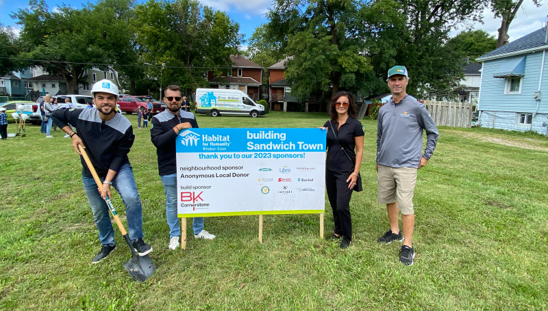 People posing with Habitat sign