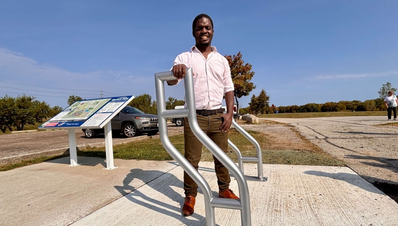 Jimmy Mugenyi, a Mechanical Engineering Technology student at St. Clair College, poses with bike racks he designed for the Malden Park Trailhead on Sept. 19, 2025.