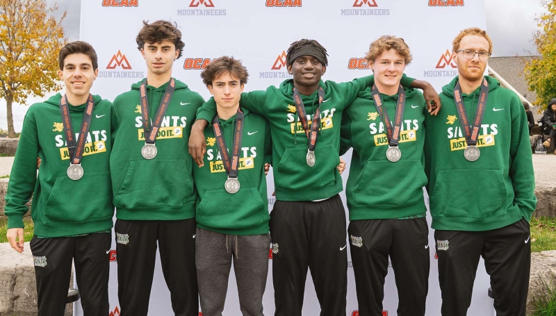 The St. Clair Saints Men's Cross-Country team posing with their silver medals